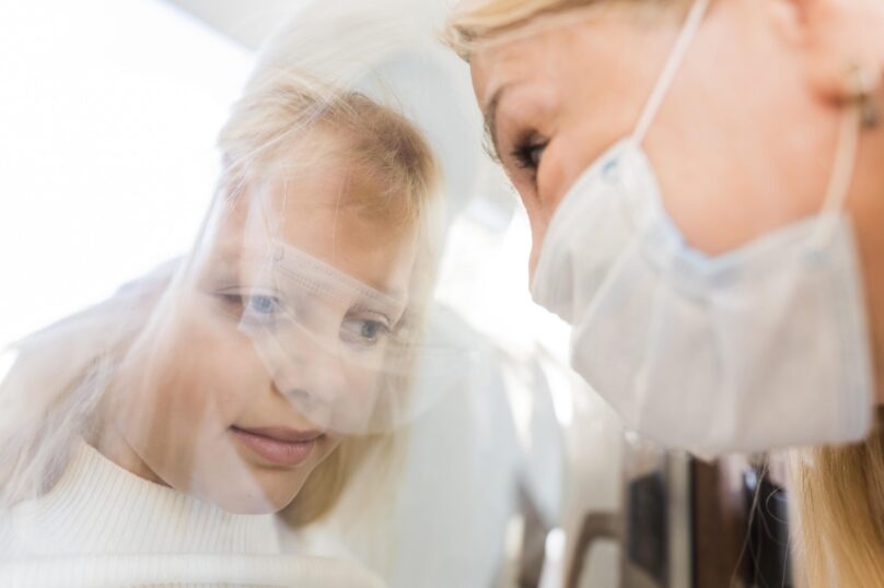 woman-with-medical-mask-quarantine-window-with-girl